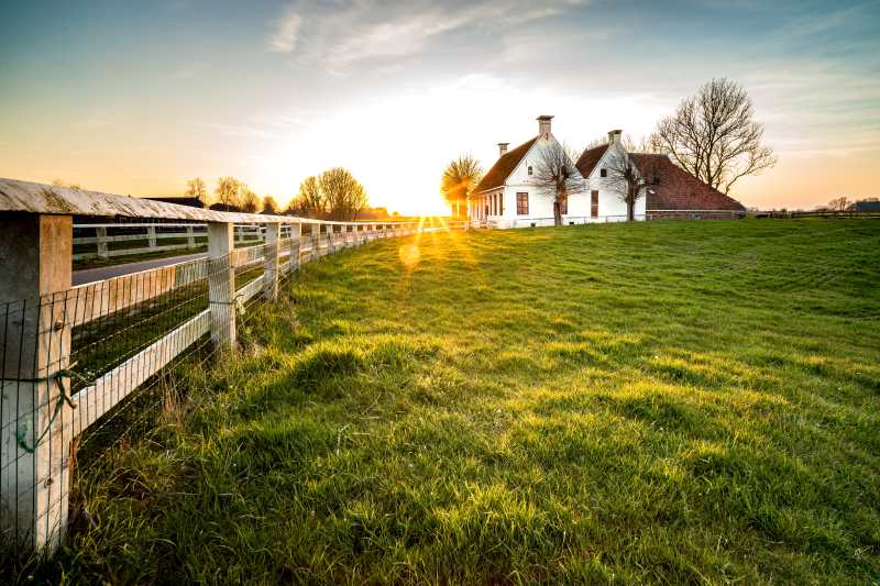 beautiful-shot-fence-leading-house-green-grass-area